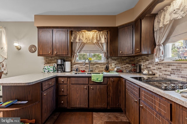 kitchen with backsplash, a peninsula, and light countertops