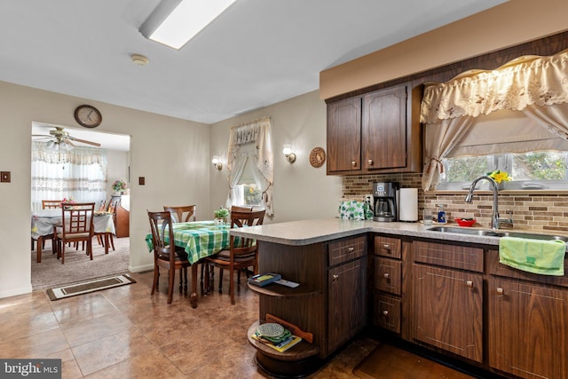 kitchen featuring light countertops, tasteful backsplash, a wealth of natural light, and a sink