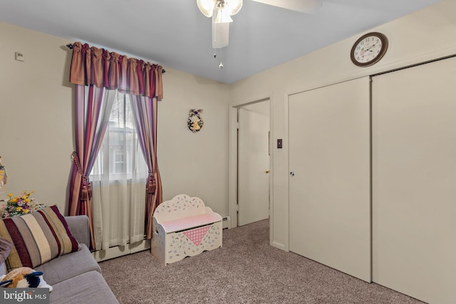 sitting room featuring a ceiling fan, baseboard heating, and carpet flooring