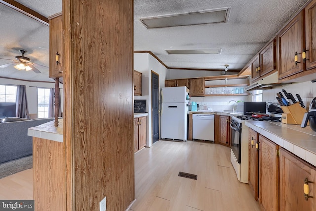 kitchen featuring tile countertops, white appliances, a textured ceiling, and crown molding