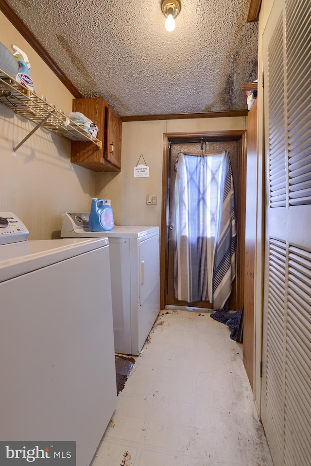 washroom featuring cabinet space, washer and dryer, a textured ceiling, and light floors