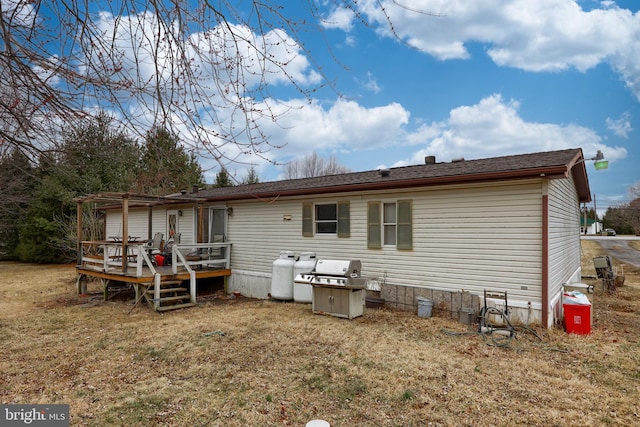 rear view of property with a yard and a deck