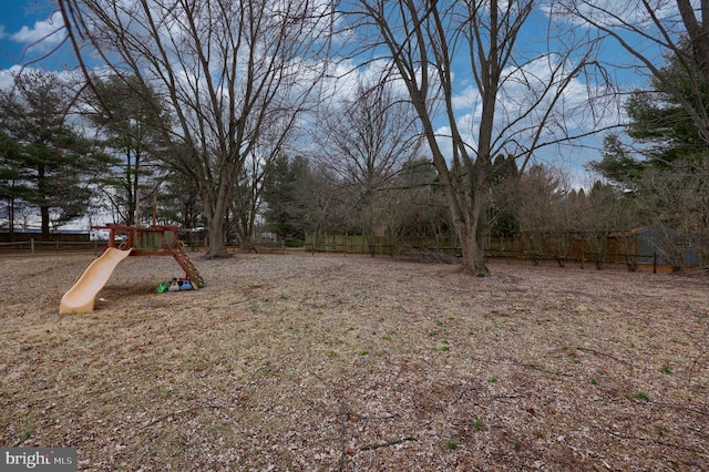 view of yard with a playground and fence