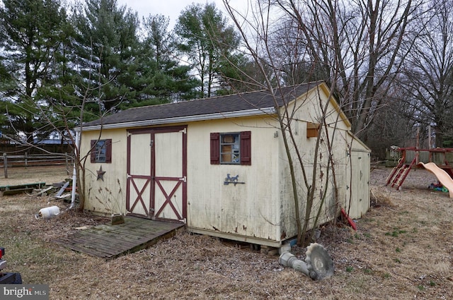 view of shed with a playground and fence