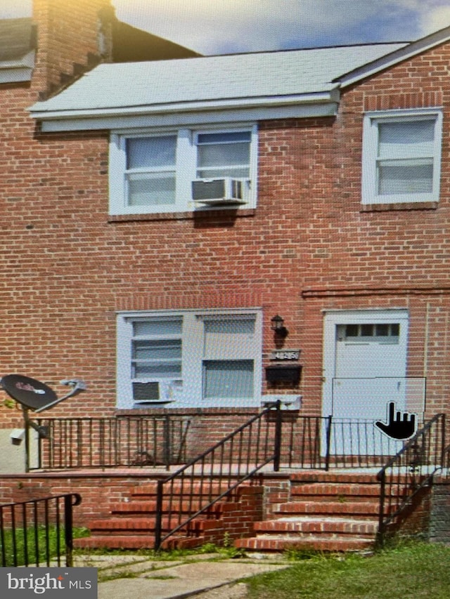 view of front of property with cooling unit and brick siding