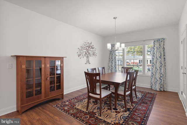 dining room featuring baseboards, an inviting chandelier, and dark wood-style flooring