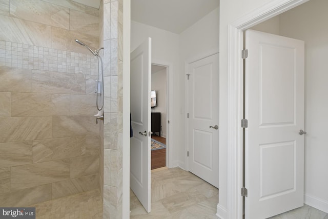 full bathroom with baseboards, marble finish floor, and a tile shower