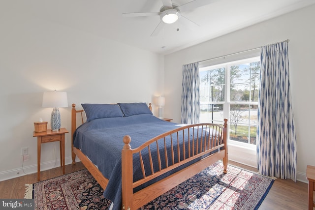 bedroom featuring multiple windows, baseboards, and wood finished floors