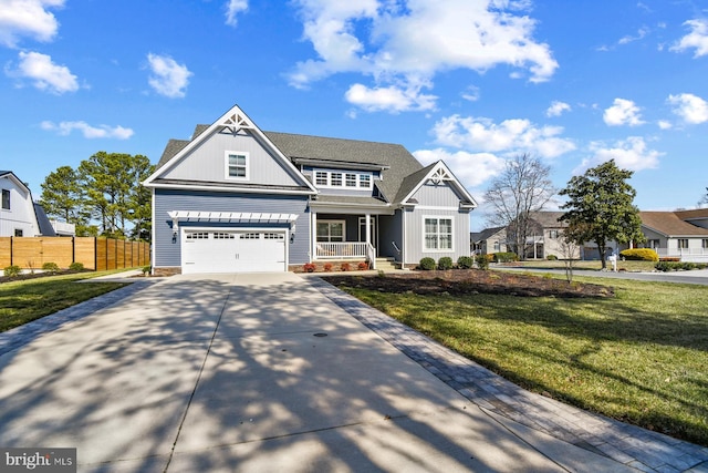 view of front of house featuring fence, covered porch, a front lawn, concrete driveway, and board and batten siding