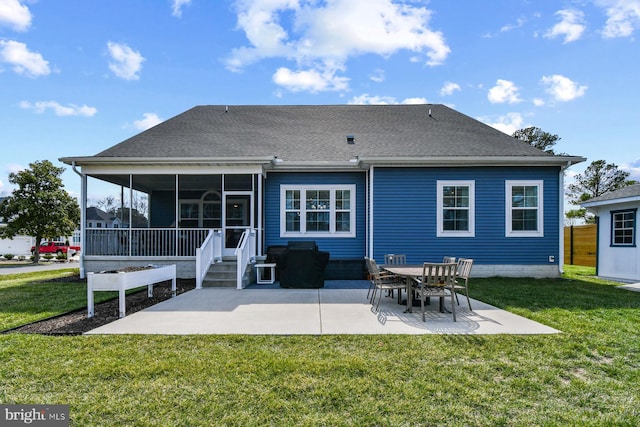 rear view of property featuring a patio area, a lawn, a shingled roof, and a sunroom