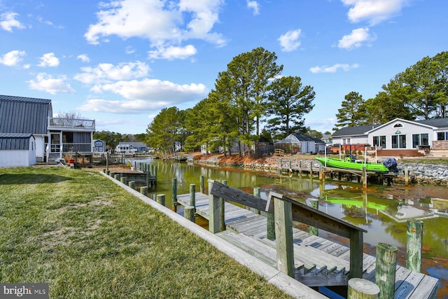 view of dock with a yard and a water view