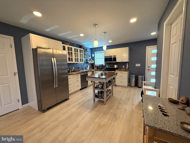 kitchen with light wood-style flooring, open shelves, white cabinetry, recessed lighting, and stainless steel appliances