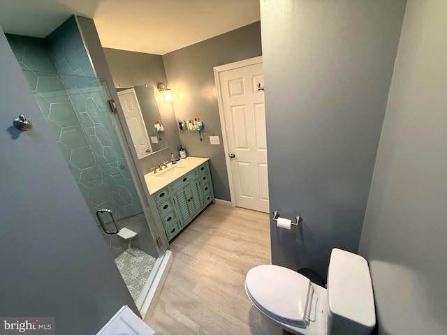 bathroom featuring a stall shower, vanity, and wood finished floors