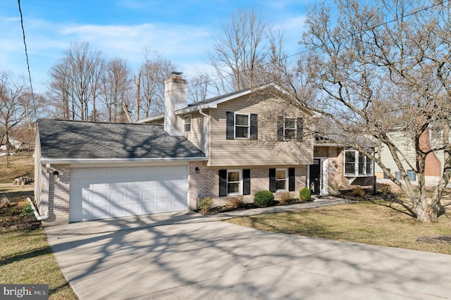 split level home with a front lawn, concrete driveway, a garage, brick siding, and a chimney