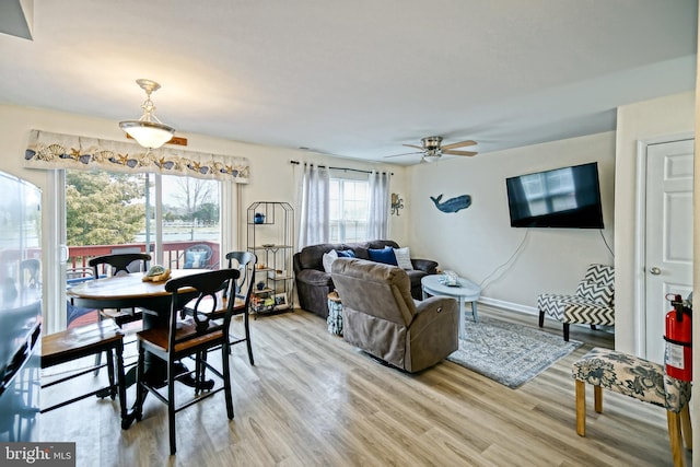 dining room with baseboards, light wood finished floors, and ceiling fan