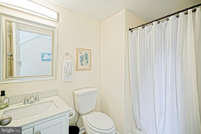 bathroom featuring a shower with shower curtain, toilet, and vanity