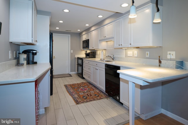 kitchen featuring white cabinetry, black appliances, wood finish floors, and a sink