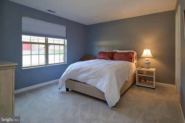 bedroom featuring visible vents, baseboards, and carpet