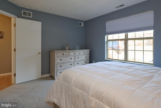 bedroom featuring light carpet, visible vents, and baseboards