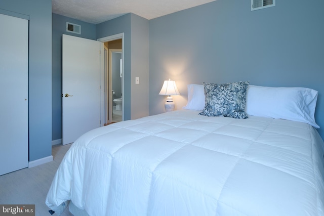 carpeted bedroom featuring baseboards and visible vents