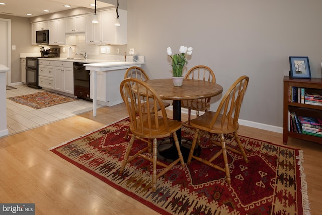 dining space with light wood-style flooring, recessed lighting, and baseboards