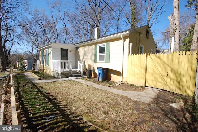 view of front of home featuring a chimney and fence