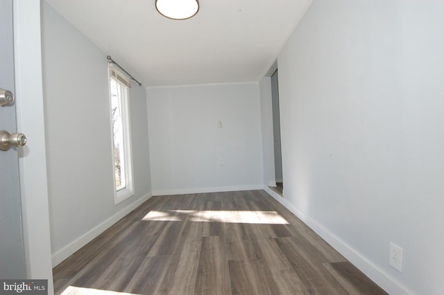 unfurnished room featuring baseboards and wood finished floors