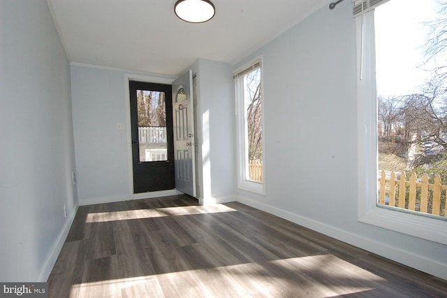 foyer featuring baseboards and wood finished floors