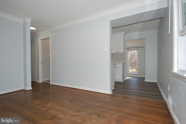 empty room featuring baseboards, dark wood finished floors, and ornamental molding