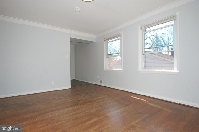 spare room featuring wood finished floors, baseboards, and ornamental molding