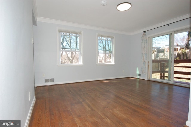 unfurnished room featuring plenty of natural light, wood finished floors, baseboards, and ornamental molding