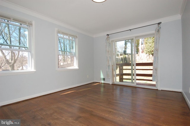 unfurnished room featuring plenty of natural light, crown molding, baseboards, and wood finished floors