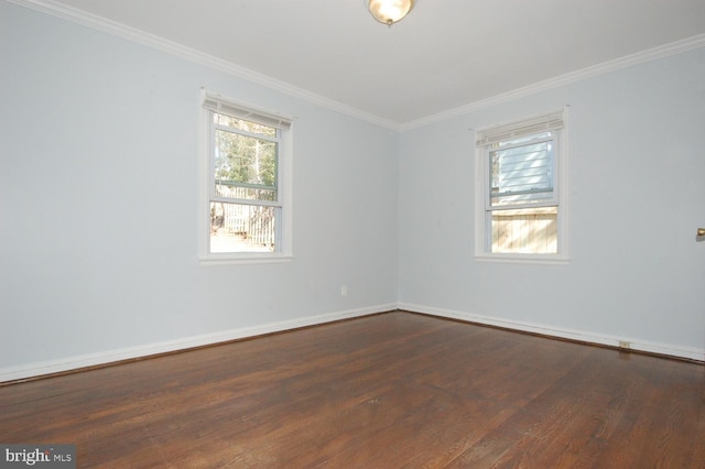 spare room with dark wood-style floors, a wealth of natural light, and ornamental molding