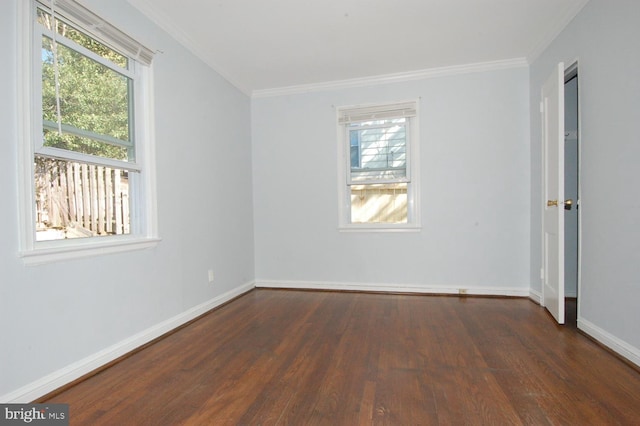 empty room with wood finished floors, baseboards, and ornamental molding