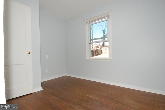 empty room with baseboards and dark wood-style flooring