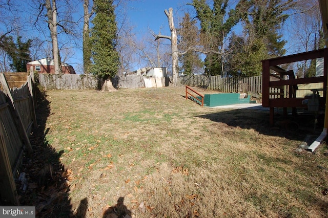 view of yard with a storage unit, an outdoor structure, and a fenced backyard