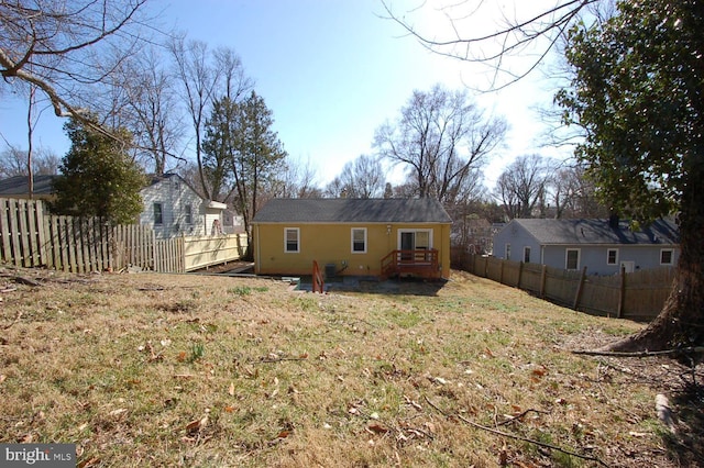 rear view of house featuring fence private yard and a lawn