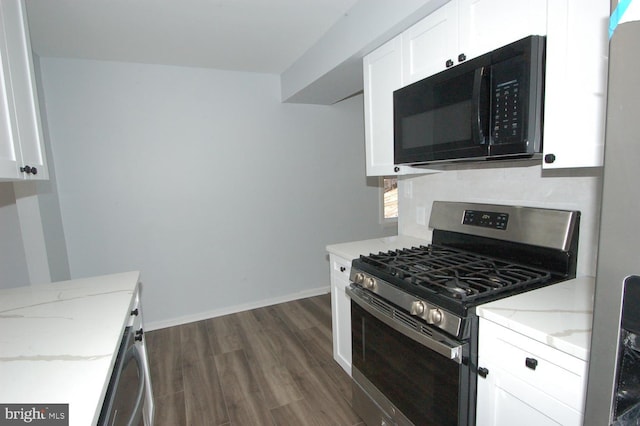 kitchen with tasteful backsplash, black microwave, light stone countertops, stainless steel range with gas stovetop, and white cabinetry