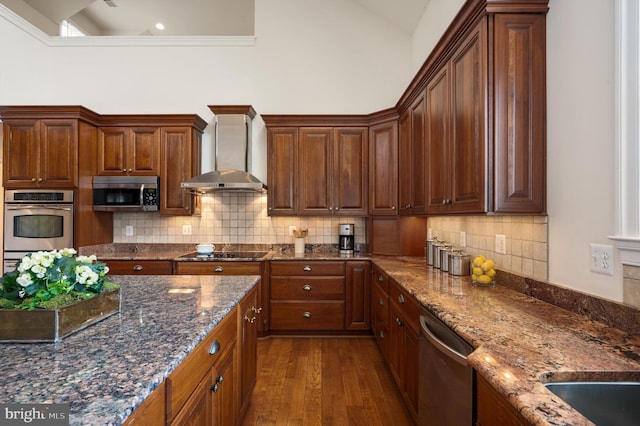 kitchen with high vaulted ceiling, dark wood finished floors, appliances with stainless steel finishes, wall chimney exhaust hood, and decorative backsplash