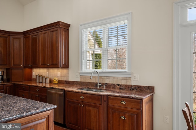 kitchen with decorative backsplash, dishwasher, dark stone counters, and a sink