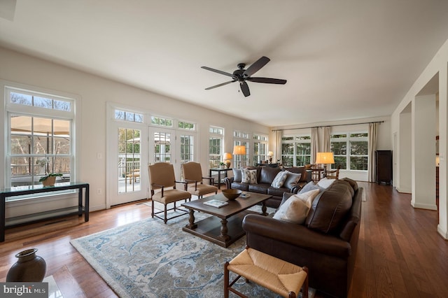 living room with baseboards, a ceiling fan, and hardwood / wood-style flooring