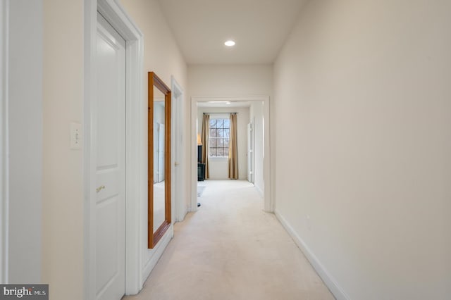 hallway with light carpet, recessed lighting, and baseboards