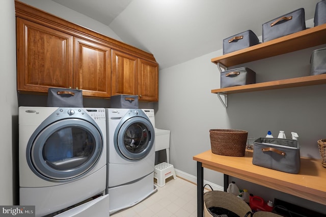 clothes washing area featuring baseboards, cabinet space, and independent washer and dryer