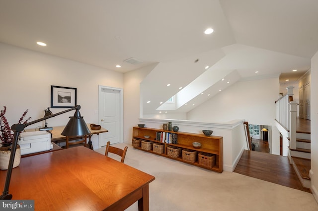 carpeted office space with vaulted ceiling with skylight and recessed lighting