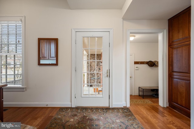 foyer entrance with baseboards and wood finished floors