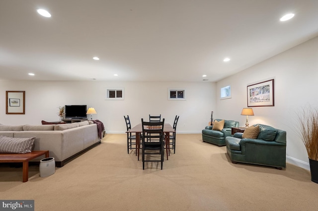 dining space with recessed lighting, light colored carpet, and baseboards