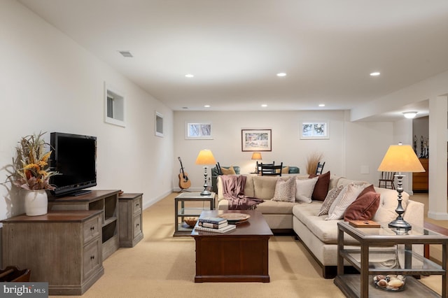 living area with visible vents, recessed lighting, light colored carpet, and baseboards