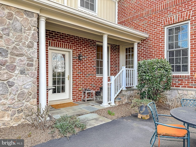 doorway to property featuring brick siding and stone siding