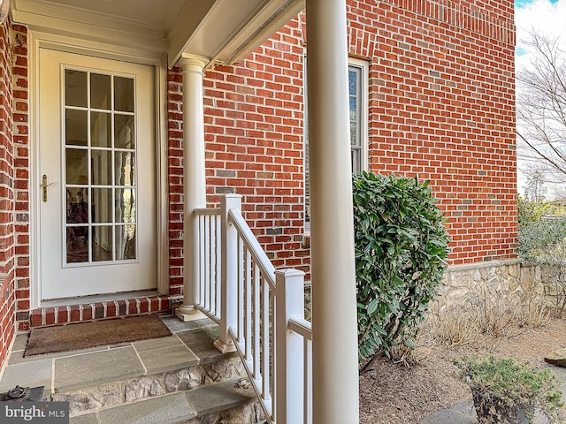 doorway to property featuring brick siding