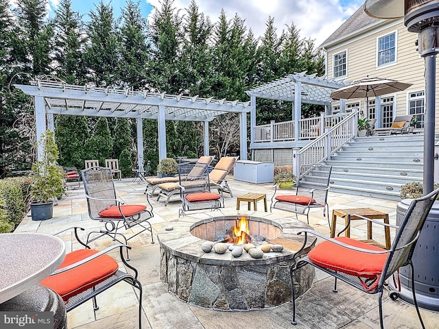 view of patio / terrace with stairway, a fire pit, and a pergola